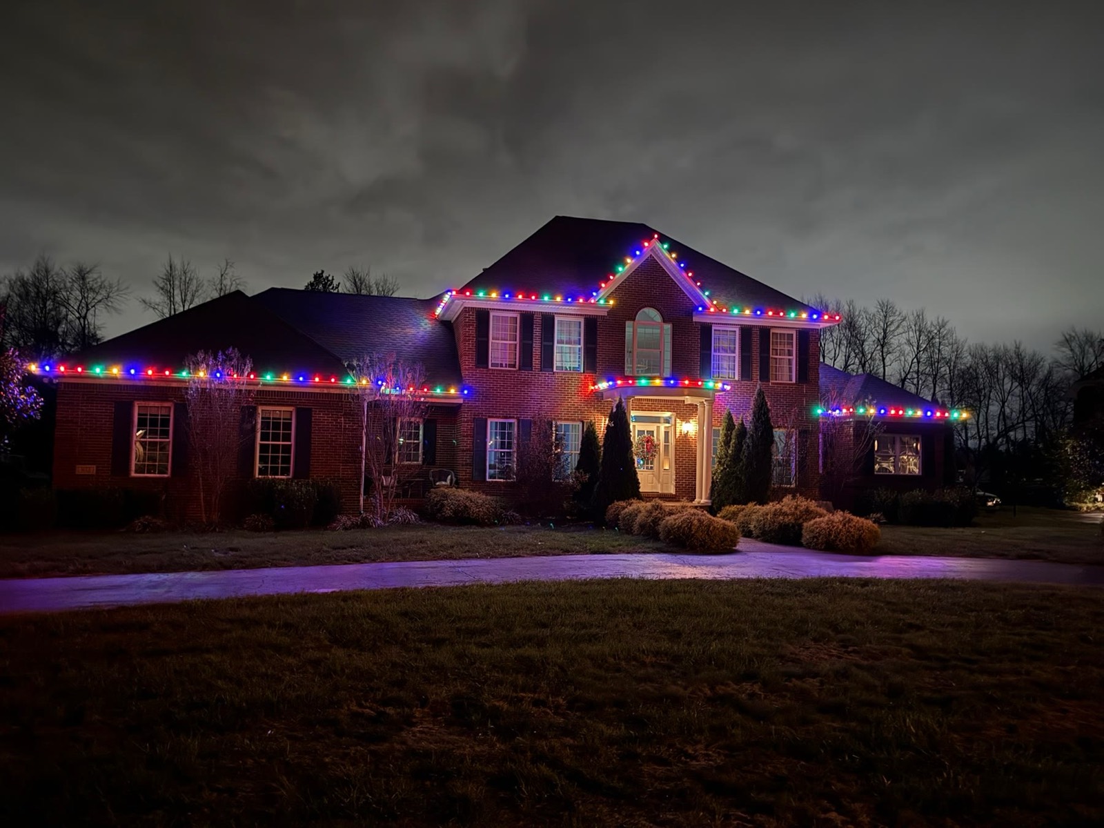 Two-story brick colonial with classic multicolor C9 roofline holiday lighting, Bowling Green KY